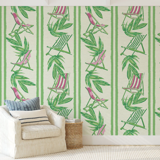 vertical linear grasscloth wallpaper print with a beachy design of green leaves and stripes paired with green and pink beach chairs arranged in a vertical oversized stripe Grasscloth Natural Textured Eco-Friendly Non-toxic High-quality  Sustainable practices Sustainability Interior Design Wall covering bold Seaside Coastal Seashore Waterfront Vacation home styling Retreat Relaxed beach vibes Beach cottage Shoreline Oceanfront Nautical