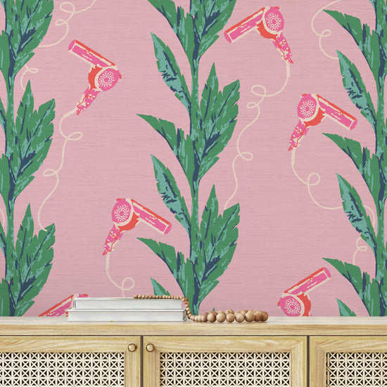 pink based printed grasscloth wallpaper with green leaf vertical stripes paired with pink hair blow dryers popping out of them.