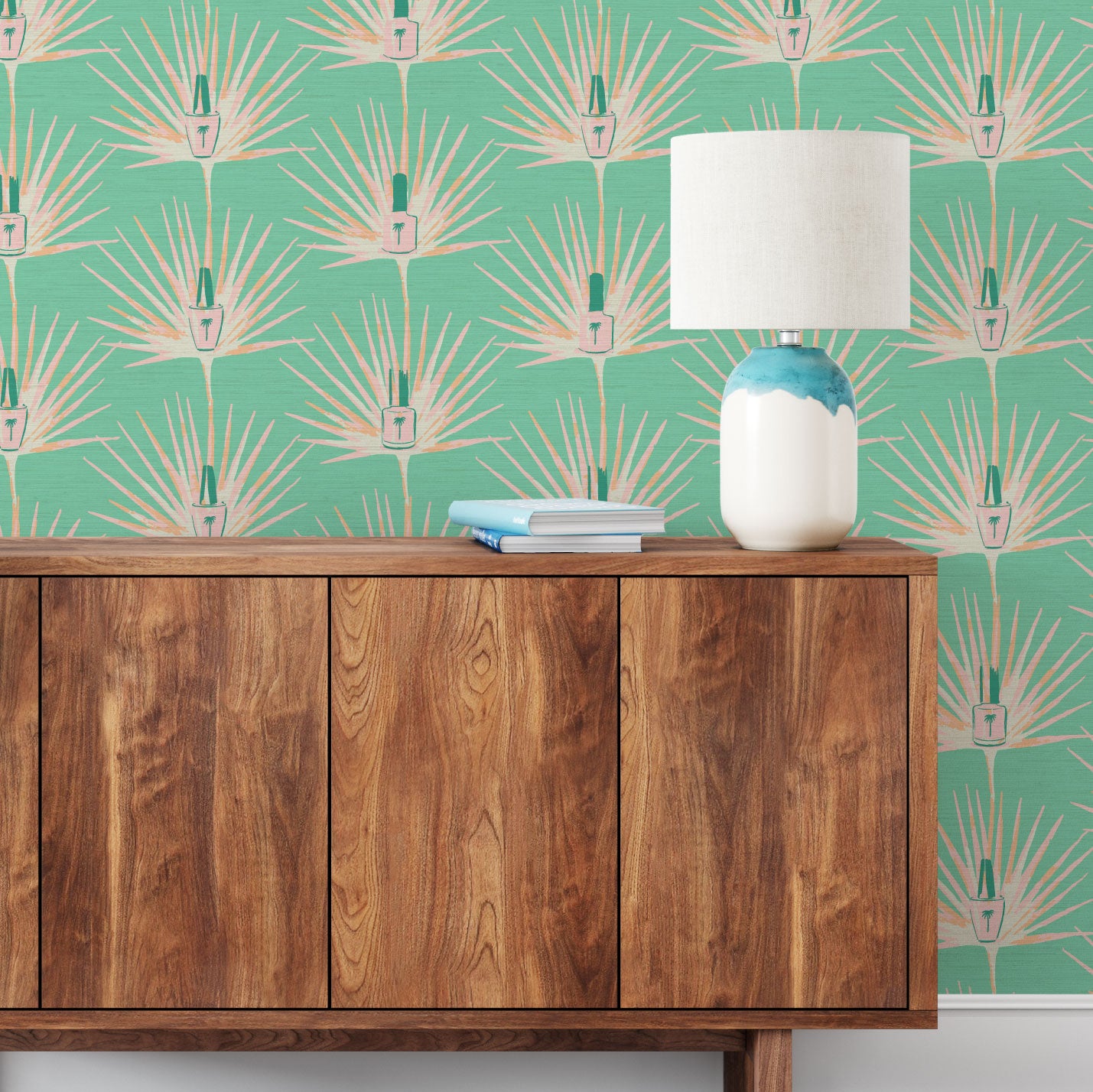 Load image into Gallery viewer, bright green printed grasscloth wallpaper featuring light pink, coral and orange palm leaves arranged in a vertical stripe layout with a bottle of nail polish in the middle.
