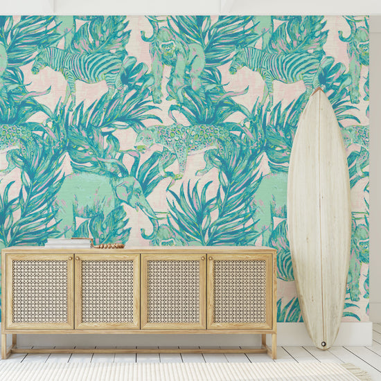 Load image into Gallery viewer, This Grasscloth Wallpaper print features elephants, gorillas, zebras and cheetahs prowling through palm leafs in this watercolor print. Print is on cream and pink base with shades of green and teal animal print with highlights of pastel neon pink
