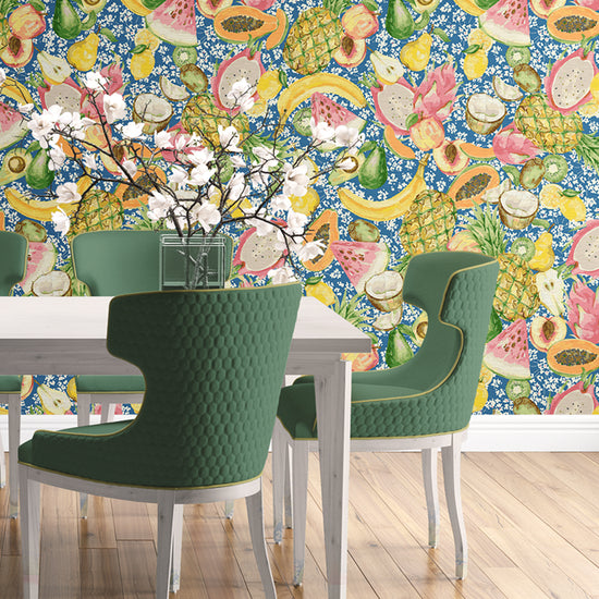 Load image into Gallery viewer, Dining room with grasscloth wallpaper hand painted with watercolors, blue based print with white ditsy florals with tossed fruit layered on top including: pineapples, limes, bananas, avocados, lemons, pears, peaches, watermelon, coconuts, mangos, bananas and passion fruit
