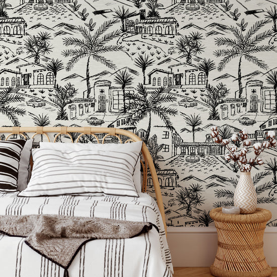 Bedroom with grasscloth printed modern toile design featuring white base and black graphic for a one color print with Spanish style houses, variety of palm trees and tropical and desert inspired plants, massive pools, vintage cars and fountains with mountains in the background.
