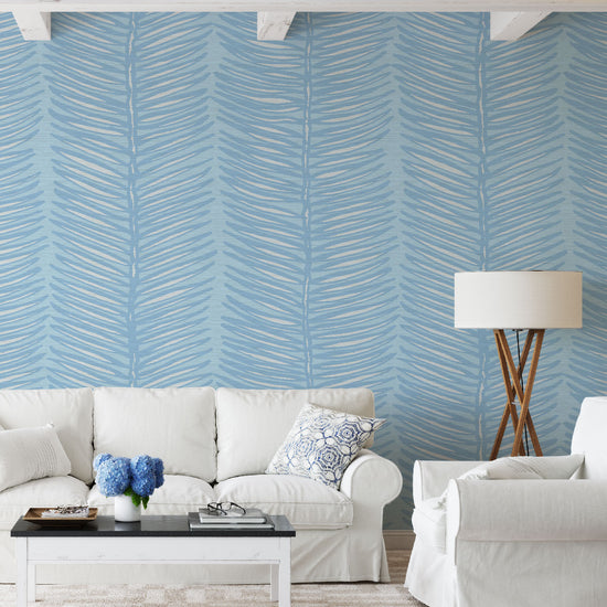 Living room with white couches and French Blue based grasscloth wallpaper with vertical linear striped fern leaves filled with white and outlined in tonally darker blue to the french blue base color